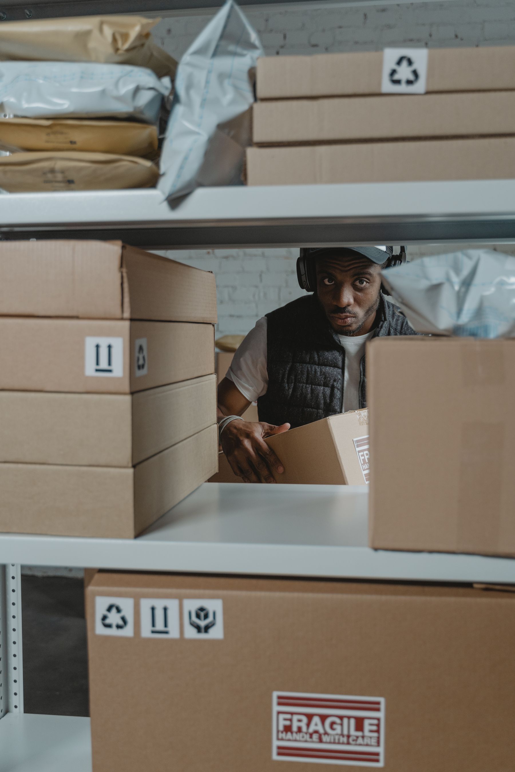 Warehouse worker organizing cardboard boxes on shelves